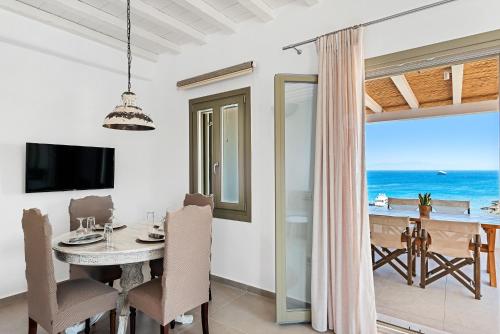 a dining room with a table and a view of the ocean at The Elaia House Mykonos in Ornos