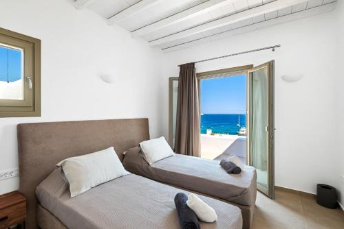 a bedroom with two beds and a view of the ocean at The Elaia House Mykonos in Ornos