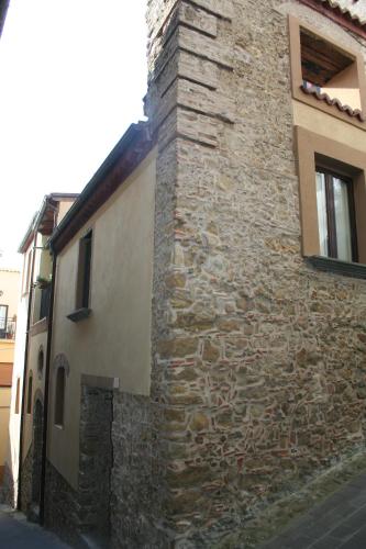 a building with a stone wall next to a street at B&B Del Borgo in San Marco Argentano