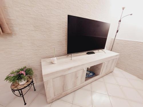 a flat screen tv sitting on top of a wooden entertainment center at Butterfly Appartamento in Meta
