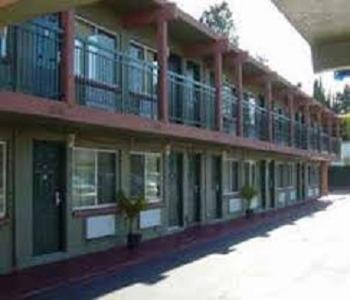 Sequoia Inn Redwood City في ريدوود سيتي: مبنى أمامه نوافذ ونباتات