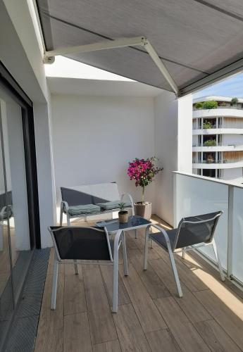 un patio avec une table et des chaises sur un balcon dans l'établissement Superbe appartement en résidence proche du centre, à Biarritz