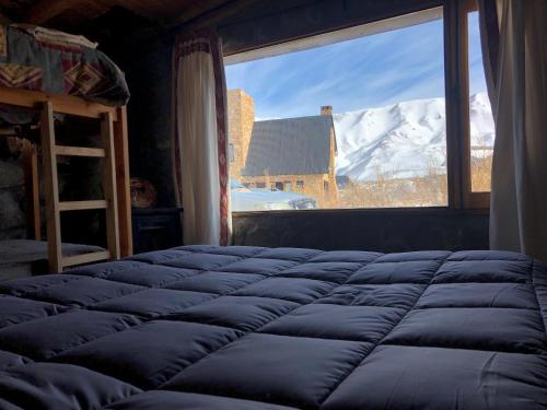 a bed in a room with a view of a mountain at Refugio Inka in Los Molles