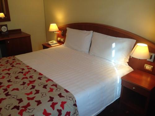 a hotel room with a large bed with red flowers on it at Hotel Piero Della Francesca in Arezzo