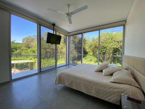 a bedroom with a bed and a flat screen tv at Peñalisa casa vacacional de lujo in Ricaurte