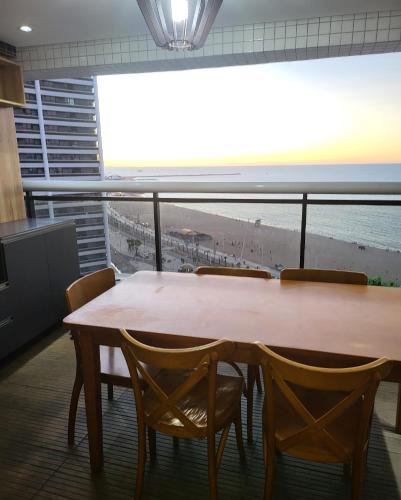 a table and chairs with a view of the beach at Beira Mar Fortaleza Landscape in Fortaleza