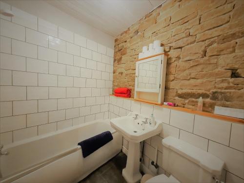 a bathroom with a sink and a bath tub and a sink at Ginnel Corner in Golcar