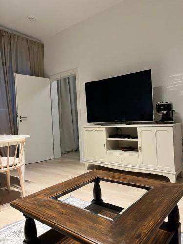 ein Wohnzimmer mit einem TV und einem Couchtisch in der Unterkunft LE-Host in Leipzig