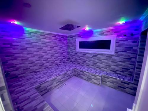 a room with a brick wall with a tv and lights at Villa nador in Nador