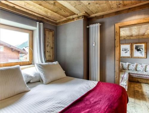 a bedroom with a large bed and a window at Neve e Sole in Selva di Val Gardena