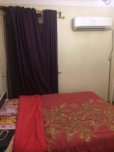 a bedroom with a red bed and a window at Smoha Zahran Haus (Private rooms or Private Apartment) in Alexandria