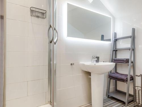 un bagno bianco con lavandino e specchio di Little Orme View a Llandudno