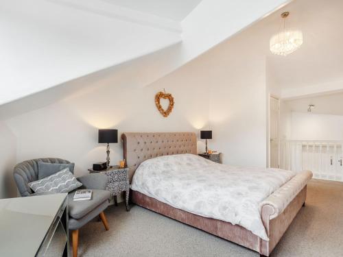 una camera da letto con un letto king size e una sedia di Little Orme View a Llandudno