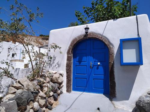 una porta blu sul lato di un edificio bianco di Mentoras' Complex a Emporio