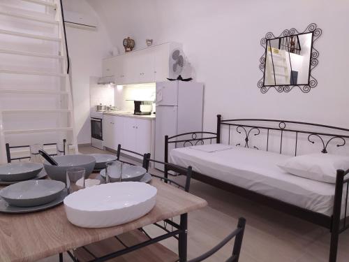 a room with two beds and a table and a kitchen at Mentoras' Complex in Emporio Santorini