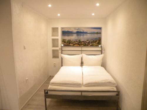 a bed in a room with a painting on the wall at Eligo in Friedrichshafen