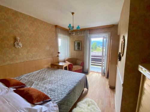 1 dormitorio con 1 cama, 1 silla y 1 ventana en COSY VINTAGE HOUSE, en Bled