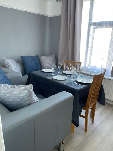 a dining room with a table and a couch at H &P accommodation in Plymouth