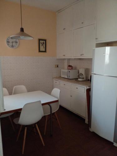 Aurora familiar في مونتيفيديو: مطبخ مع طاولة وثلاجة بيضاء