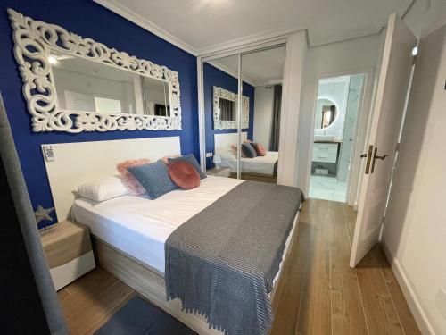 1 dormitorio con 1 cama con paredes azules y espejo en Villa Moleiro - Golf del Sur, en San Miguel de Abona