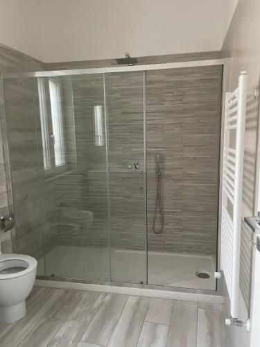 a bathroom with a glass shower with a toilet at B&B Eden in Scafati
