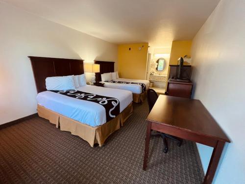 a hotel room with two beds and a desk at Celebrity Inn in Branson