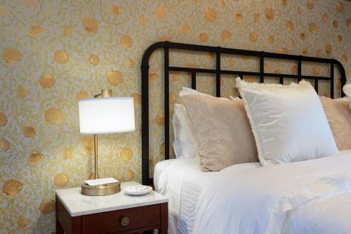 a bedroom with a bed and a table with a lamp at Mill Rose Inn in Half Moon Bay