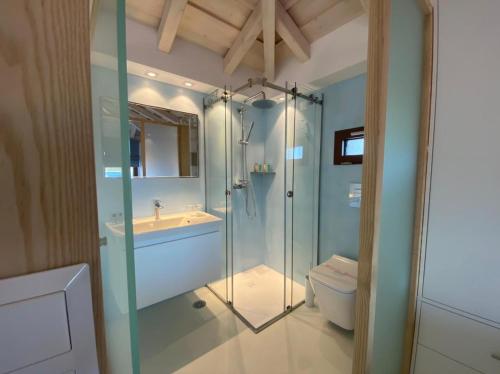 uma casa de banho com um chuveiro, um lavatório e um WC. em Magic Hotel em Agia Paraskevi