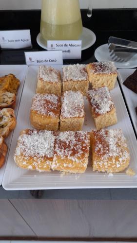 a tray of pastries with powdered sugar on them at NOVO HOTEL in Conceição do Coité