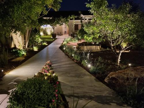 a walkway in a garden at night with lights at בית בעמק in Merhavyāh