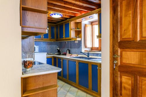 cocina con armarios azules y nevera blanca en Floral Villa with marvelous view to Mykonos town en Mykonos
