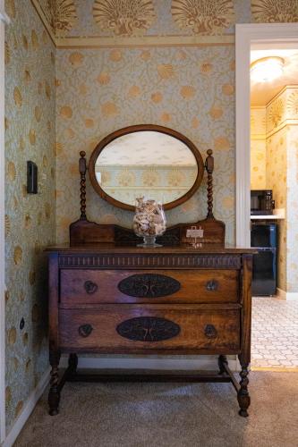 a dresser in a room with a mirror on the wall at Mill Rose Inn in Half Moon Bay