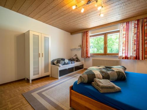 Un dormitorio con una cama azul y una ventana en Ferienhaus Schlitters en Fügen