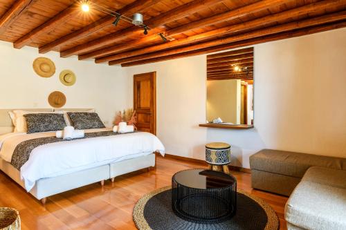 1 dormitorio con 1 cama y 1 sofá en Floral Villa with marvelous view to Mykonos town en Mykonos