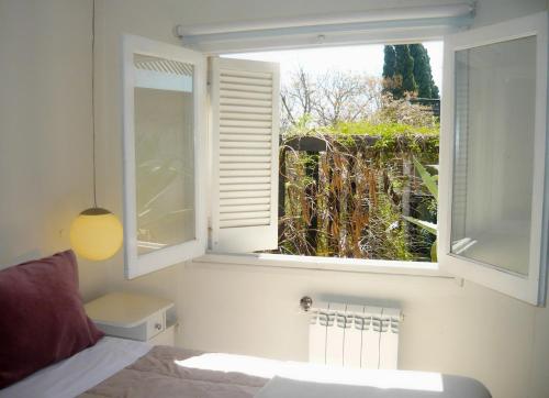 a bedroom with a bed and a window with a view at Mousai Hotel Boutique in Capilla del Monte