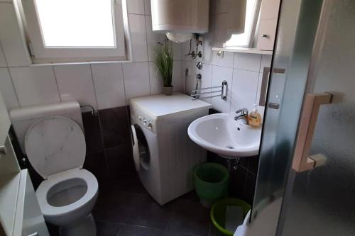a small bathroom with a toilet and a sink at Apartments with parking space Makarska - 6850 in Makarska