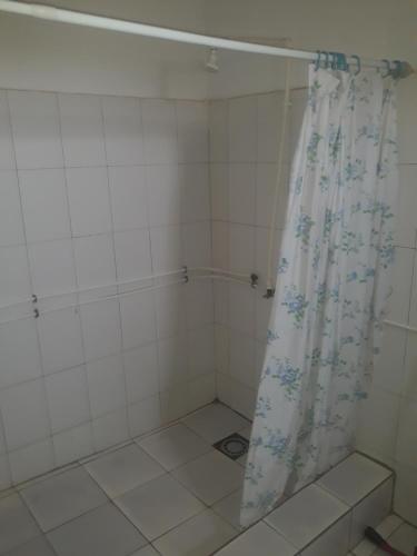a white tiled shower with a shower curtain at transit in Nouakchott