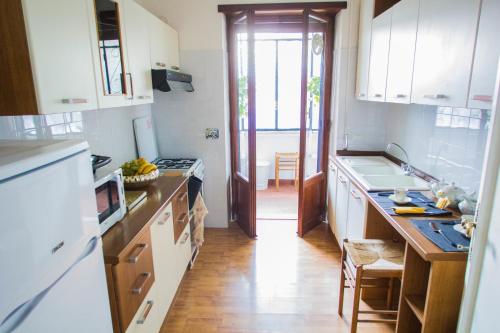 une cuisine avec des armoires blanches et un plancher en bois dans l'établissement Vatican House Apartment, à Rome