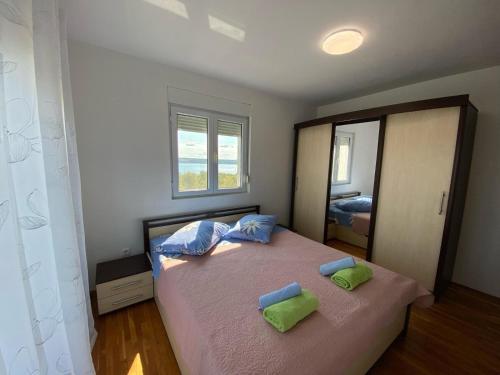 a bedroom with a bed with two pillows and a mirror at Apartment Maslenica 12636a in Jasenice