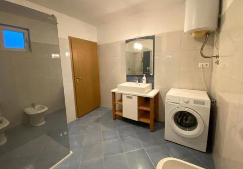 a bathroom with a washing machine and a sink at Apartment Maslenica 12636a in Jasenice