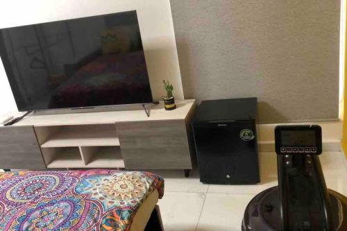 a living room with a flat screen tv on a stand at Nuevo penthouse con terraza privada, alberca , area infantil y pet friendly in Manzanillo