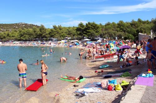 a large group of people at a beach at Apartment Tisno 4295d in Tisno
