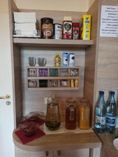 a kitchen pantry with food and drinks on shelves at Hotel AI Königshof in Berlin