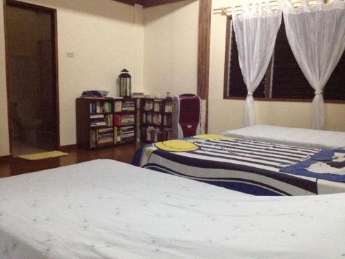a bedroom with two beds and a book shelf at Liwayway sa Bohol Pamilacan Resort in Baclayon