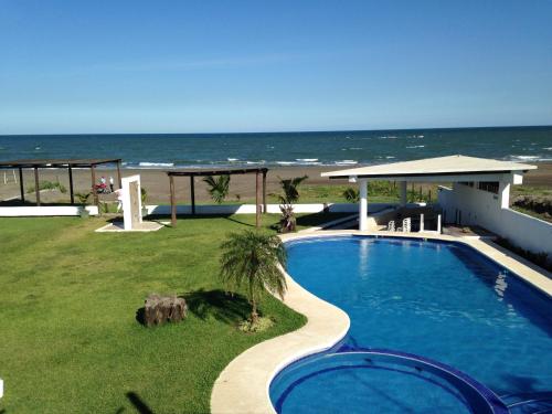 una piscina con la playa de fondo en Hotel Arrecife Chachalacas, en Chachalacas