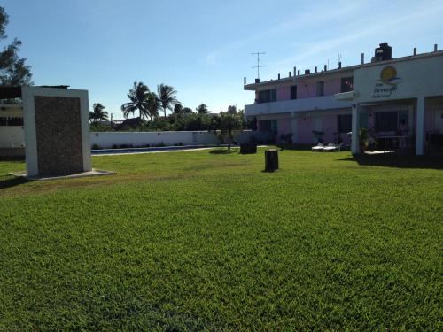 a large field of grass in front of a building at Hotel Arrecife Chachalacas in Chachalacas