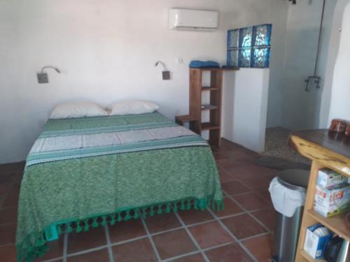 1 dormitorio con 1 cama con edredón verde en The O'asis, en La Ribera