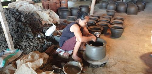 a woman is sitting in a pot in a room at Villa Kayu Yogyakarta in Yogyakarta