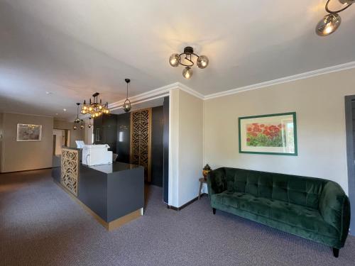a living room with a green couch and a table at Hotel Casa Andalucia in Hallbergmoos