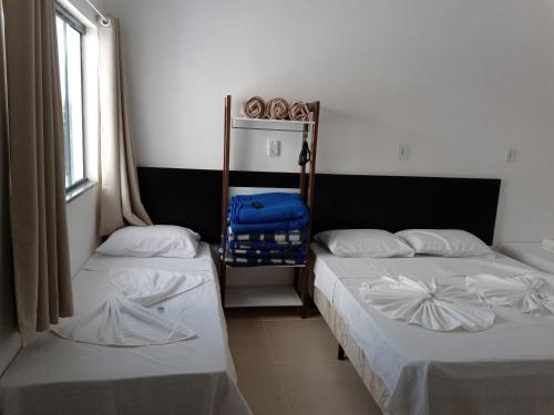 a room with two beds and a window at Hotel Pousada Santa Maria in Aparecida